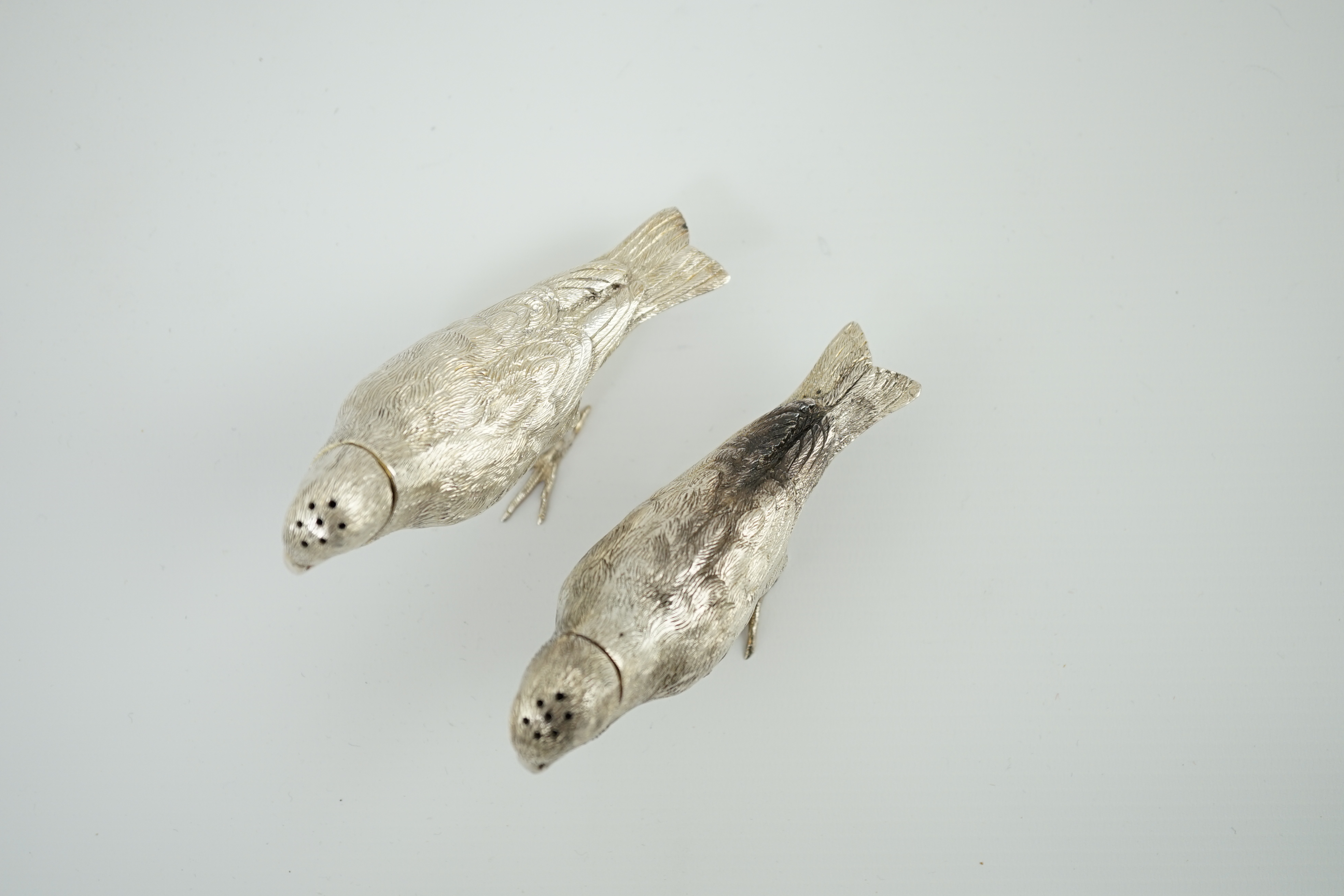 A pair of Elizabeth II silver novelty free-standing pepperettes, modelled as sparrows, by Israel Freeman & Son Ltd